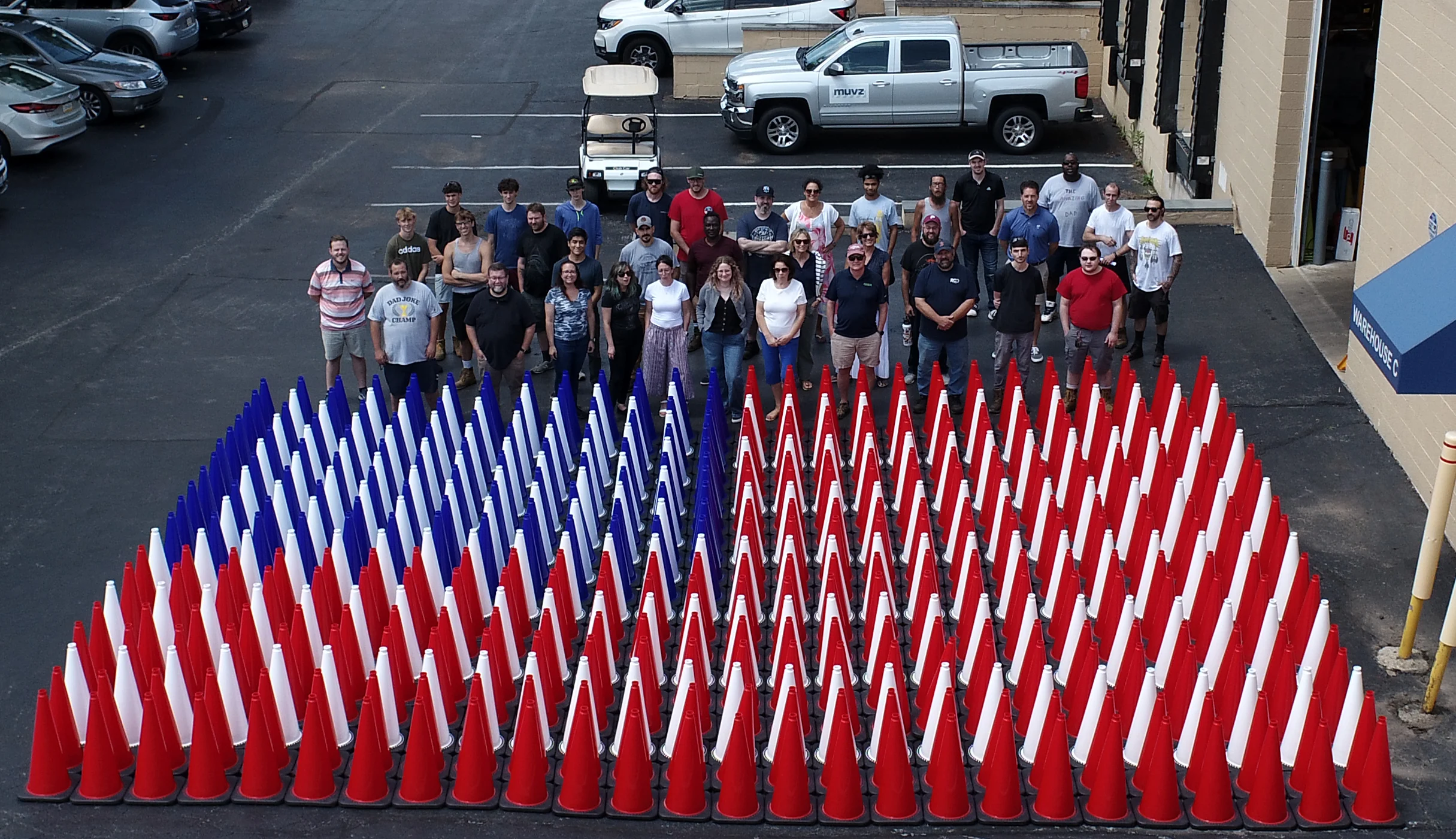 Team members standing behind rows of traffic cones